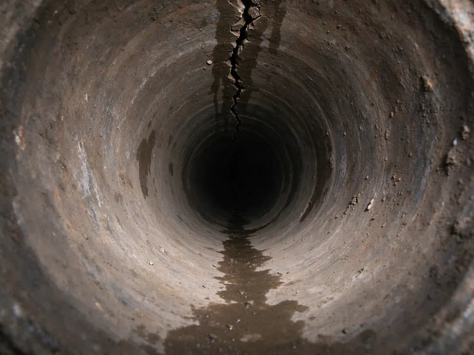 Sewer camera view of a lengthwise crack along the crown of a clay sewer pipe