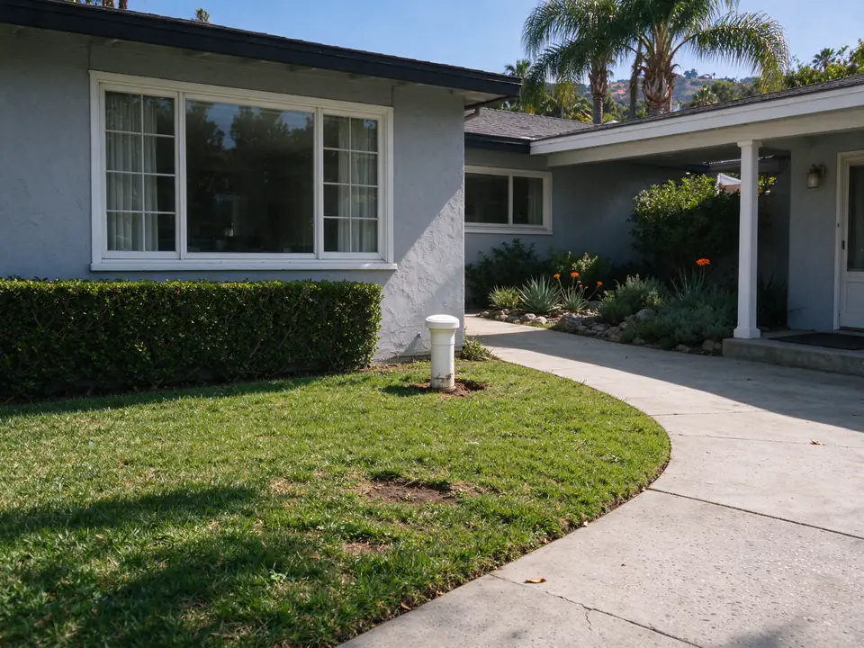 Front-yard sewer cleanout near the foundation of a Los Angeles ranch house
