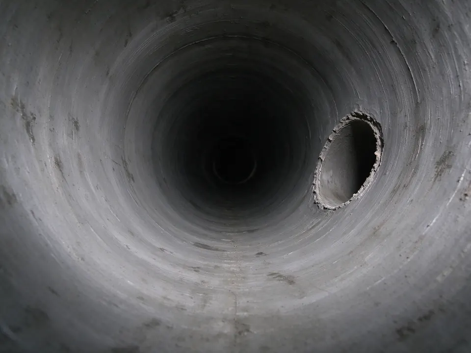Sewer camera view of a reinstated branch connection cut through a cured pipe liner
